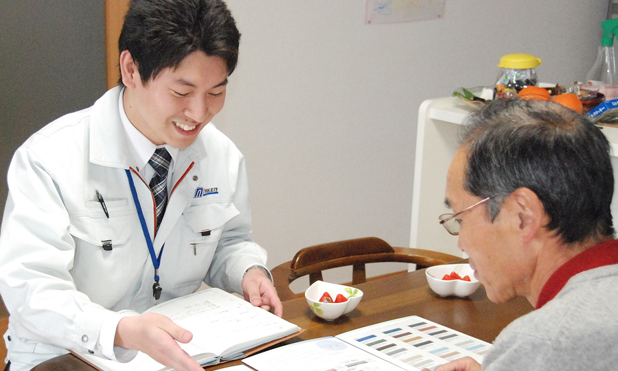 夫婦に説明をする男性スタッフの写真